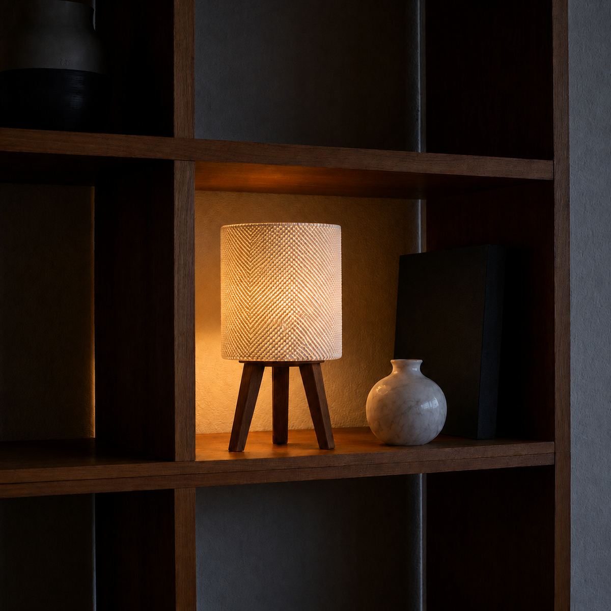 Kete lattice table lamp glowing at night, dark bookshelf white vase, LAYR, made in New Zealand