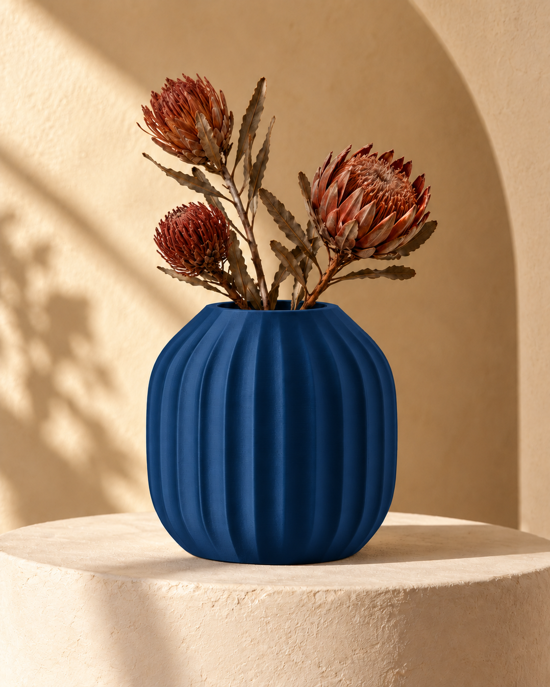 Marama round pleated vase in Dark Blue, with dried stems, sculptural cream plinth, LAYR, made in New Zealand