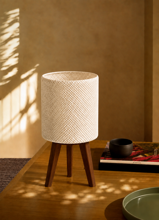 Kete lattice table lamp on a coffee table in warm sunlight, matte white woven shade, LAYR, made in New Zealand