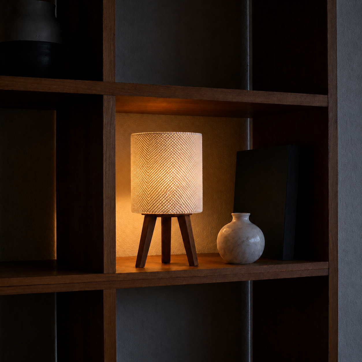 Kete lattice table lamp glowing at night, dark bookshelf white vase, LAYR, made in New Zealand